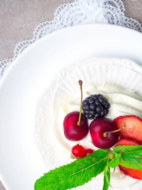 Çilek, kiraz, böğürtlen, çilek ve nane ile Pavlova kek