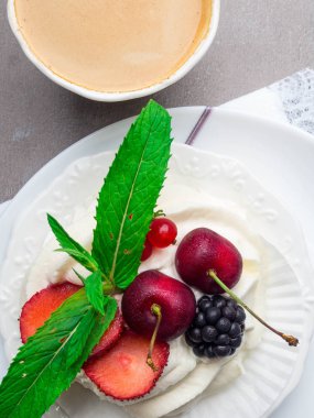 Krem şanti ve nane yaprağı dekorasyon ve kahve fincan ile Tatlı pavlova beze