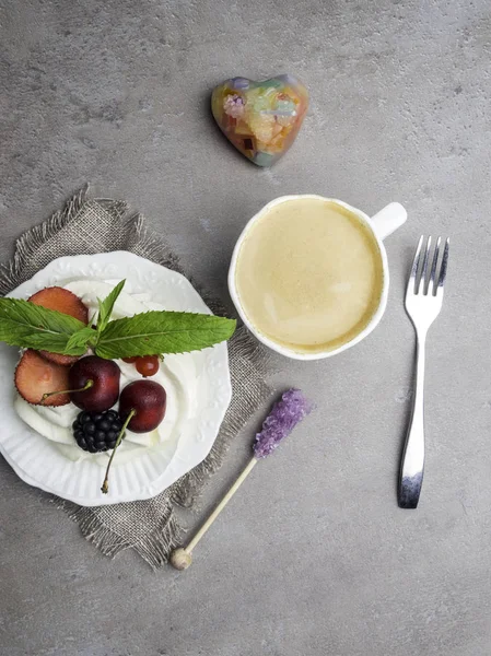 Merengue pastel de postre Pavlova con bayas frescas en un plato y una taza de café. Fondo de piedra, primer plano — Foto de Stock