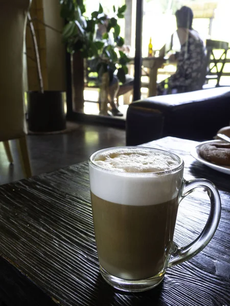 Copo de vidro de café latte na mesa de madeira — Fotografia de Stock