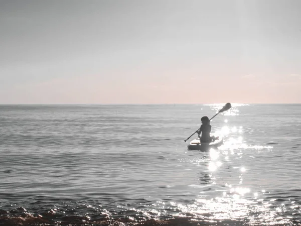 Un giovane ragazzo carino nel surf SAP, un ragazzo galleggia su una tavola sull'acqua, uno stile di vita attivo — Foto Stock