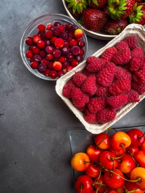 Beton arka planda meyveler. Yaz veya Bahar Organik Berry. Çilek, ahududu, kiraz, kızılcık. Tarım, Hayvancılık, Hasat Konsepti