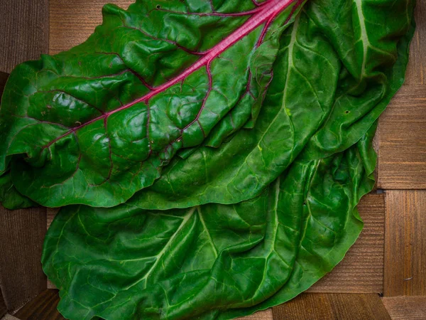 Fresh chard mangold salad leaves in old basket background. Top view. Healthy eating theme. — Stock Photo, Image