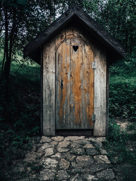 Old wooden restroom in a forest