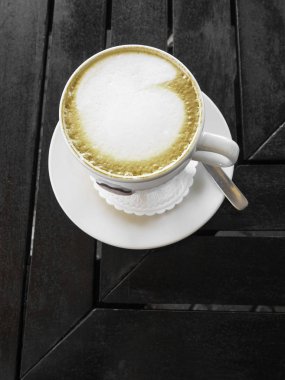 Ahşap arka plan üzerinde latte sanat kahve