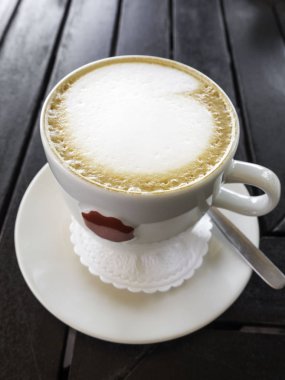 ahşap arka plan üzerinde kapuçino veya latte. Güzel köpük, seramik bardak, şık tonlama, metin için yer.