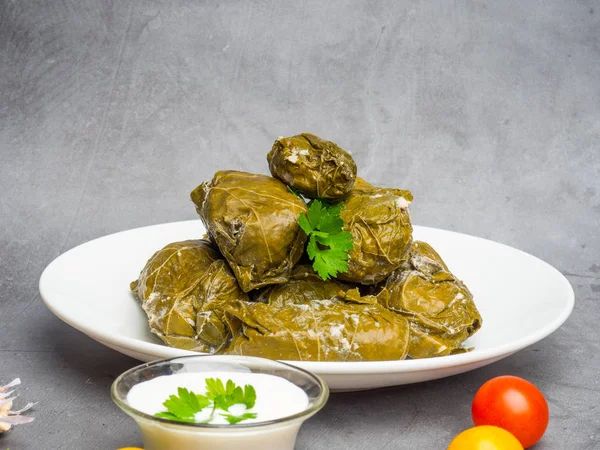 Köstliche Dolma Sarma gefüllte Traubenblätter Reis, weiße Joghurt-Sauce. libanesische dolma sarma auf teller. libanon türkisch griechisch mittelöstliche Küche. Abendessen Essen dolmadakia oder dolma. Yaprak-Sarma — Stockfoto