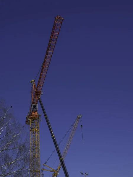 Construction cranes against the blue sky background — Stock Photo, Image