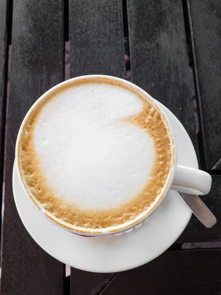 Smaczne białe filiżanki cappuccino z Latte Art na drewnianym stole. — Zdjęcie stockowe