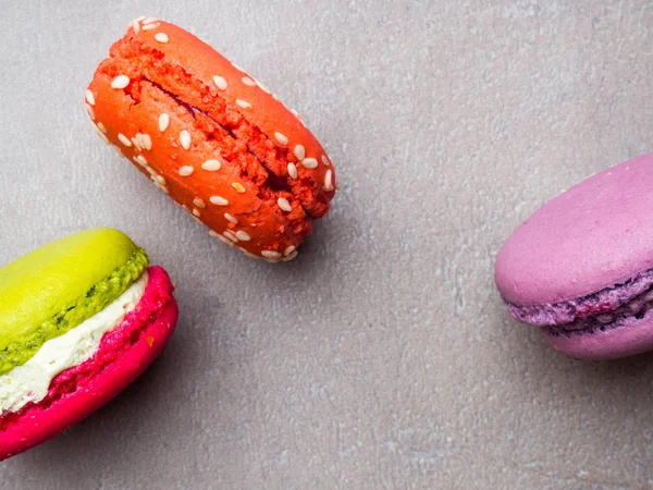 Diferentes tipos de macarrones en movimiento cayendo sobre fondo rosa. Macarrones franceses dulces y coloridos cayendo o volando en movimiento . — Foto de Stock