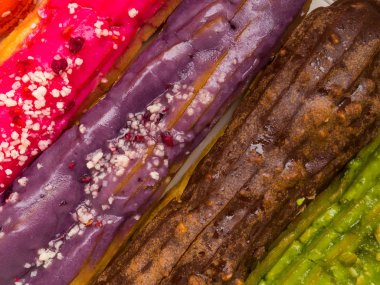 renkli Eclairs arka plan, Berry ile pembe, Antep fıstığı ile yeşil, çikolata, ve mor renk