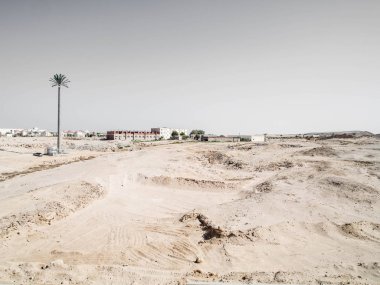 Çölde yol palmiye, evler ile yan görünüm