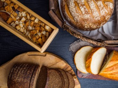 Ahşap bir masanın üzerinde yatan taze ekmek ve kraker çeşitli