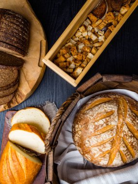 Ahşap bir masanın üzerinde yatan taze ekmek ve kraker çeşitli