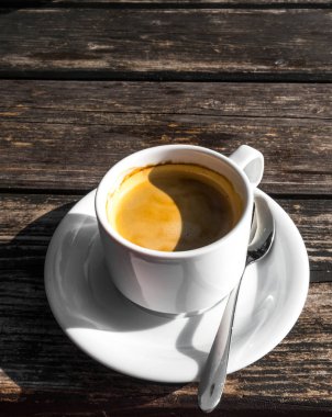 coffe fincan, gölge Yin Yang görüntü şekli, ahşap arka plan üzerinde. Beyaz seramik bardak, şık tonlama, kopyalama alanı