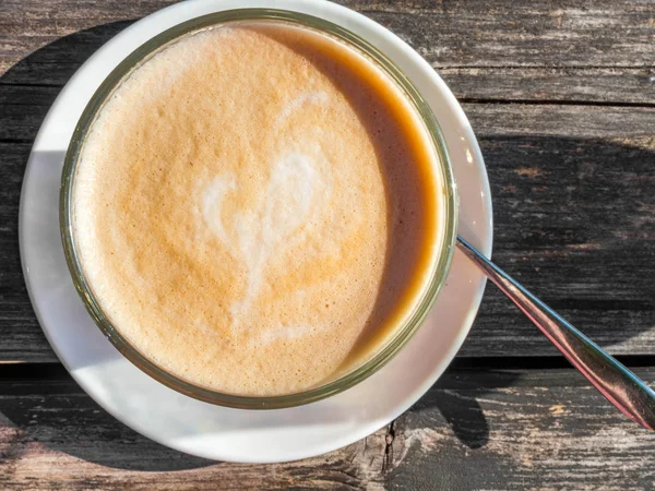 Copo de vidro de café latte na mesa de madeira — Fotografia de Stock