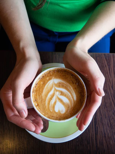 Γυναικεία χέρια που κρατούν φλιτζάνια καφέ σε σκούρο ξύλινο φόντο τραπεζιού, κορυφαία θέα. — Φωτογραφία Αρχείου