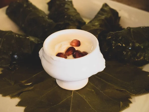 Köstliche Dolma Sarma gefüllte Traubenblätter Reis, weiße Joghurt-Sauce. libanesische dolma sarma auf teller. libanonisch türkisch griechisch nahöstliche Küche — Stockfoto