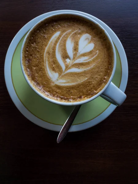 Cerrar taza de café blanco con forma de espuma de arte latte en la mesa de madera . — Foto de Stock