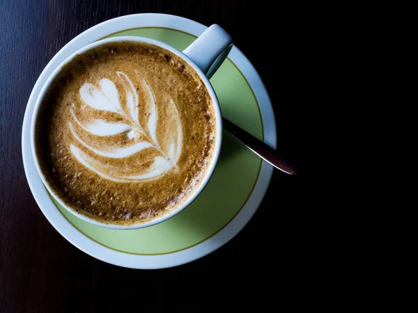 Tutup cangkir kopi putih dengan busa seni latte berbentuk di meja kayu . — Stok Foto