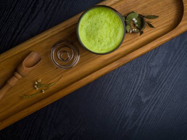 ahşap arka plan üzerinde sıcak matcha kahve latte cam. Güzel köpük, metin için yer.