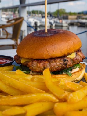 salata süslemeleri, patates kızartması ile lezzetli sığır burger. Ahşap bir tahta açık cheeseburger
