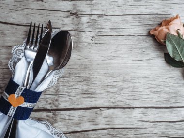 Açık pastel renkli sofra seti: peçete ve narin pembe kopya alanı ile rustik eski püskü ahşap arka plan üzerinde yükseldi vintage gümüş. Üstte görüntü.