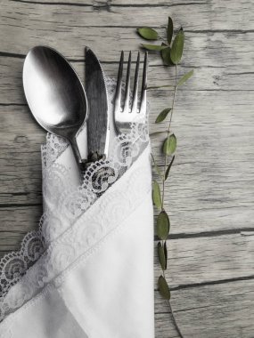 Noel yemeği için şenlikli bir yer ayarı. Kopya alanı ile eski ahşap arka plan üzerinde beyaz peçete ve köknar koni vintage çatal