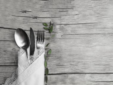 Ahşap arka plan üzerinde bıçak, çatal, kaşık çatal ve yeşil dal