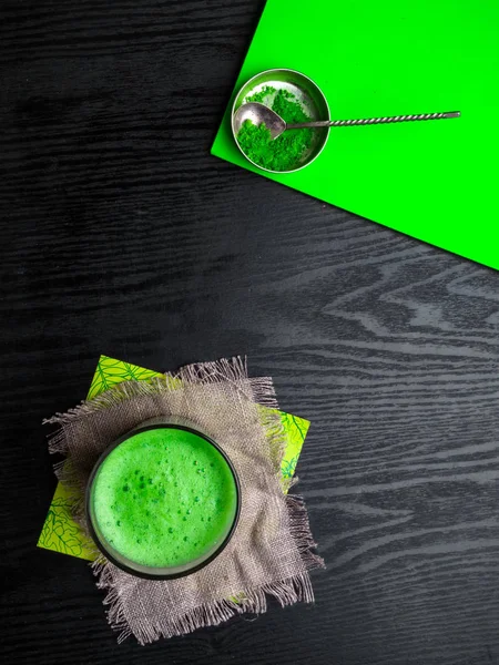 Matcha green tea latte in a glass. Top view. Copy space. Energy boost, healthy benefits, detox and antioxidants drink