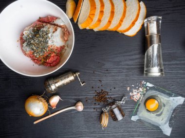 et köftesi, rissole Malzemeler: çiğ kıyma, çiğ yumurta, doğranmış soğan, sarımsak, ekmek, otlar, tuz ve biber ahşap arka plan üzerinde