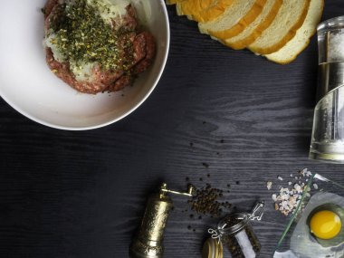 kıyma, ekmek dilimleri, baharatlar, biber, ahşap arka plan üzerinde yumurta, boş alan. Farklı kıyma pişirmek için hazırlanan malzemeler, rissole Top görünümü.