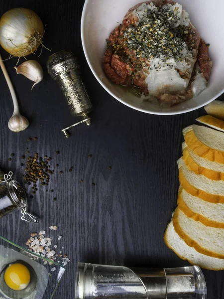 et köftesi, rissole Malzemeler: çiğ kıyma, çiğ yumurta, doğranmış soğan, sarımsak, ekmek, otlar, tuz ve biber ahşap arka plan üzerinde