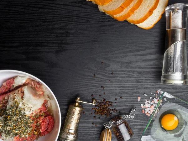 kıyma, ekmek dilimleri, baharatlar, biber, ahşap arka plan üzerinde yumurta, boş alan. Farklı kıyma pişirmek için hazırlanan malzemeler, rissole Top görünümü.