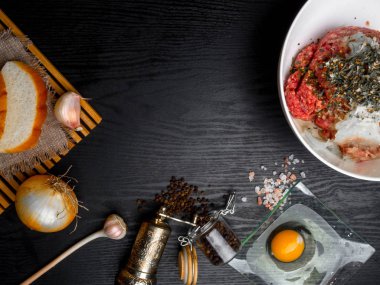 Yumurta, et, ekmek, soğan, sarımsak, tahta üzerine otlar, kopya alanı gibi malzemelerle köfte hazırlanması