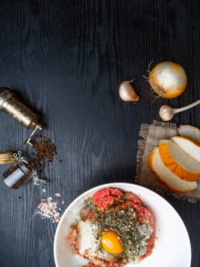 Yumurta, et, ekmek, soğan, sarımsak, tahta üzerine otlar, kopya alanı gibi malzemelerle köfte hazırlanması
