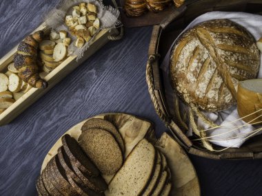 Ahşap bir masanın üzerinde yatan taze ekmek çeşitli