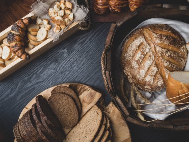 Ahşap bir masanın üzerinde yatan taze ekmek çeşitli