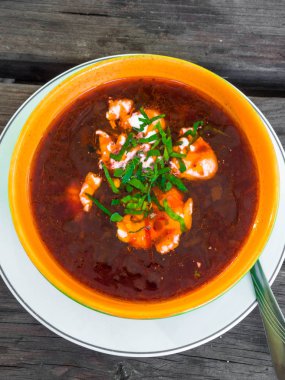 Kırmızı çorba et parçaları ile borsch denir, ekşi, ahşap arka plan üzerinde maydanoz. Ukrayna mutfağı. üst görünüm.