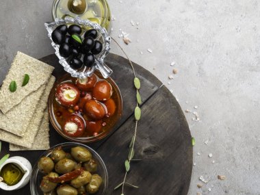 Kraker, zeytinyağı, gri taş kayrak üzerinde peynir, zeytin ve otlar ile doldurulmuş mini biber ile İtalyan gıda maddeleri arka plan