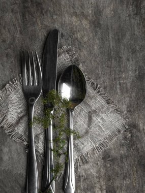 Ahşap masa üzerinde gümüş tonlu Noel masası ayarı, ahşap masa üzerinde yeşil dalı ile