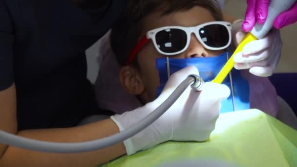 Un niño pequeño en el consultorio de odontología, dientes tratados con niños en la clínica dental — Vídeos de Stock