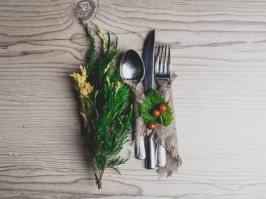 Noel masası: bıçak kaşık çatal, çuval peçete ve kopya alanı ile ahşap bir masa üst görünümü nde Noel ağacı dalı. Şenlikli masanın yeni yıl dekoru.