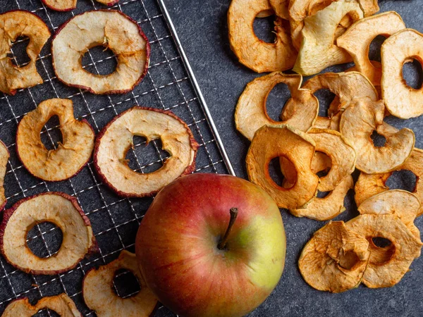 Dried slices of red and yellow apples, and fresh apple, rich in fiber and iron, healthy snack — Stock Photo, Image