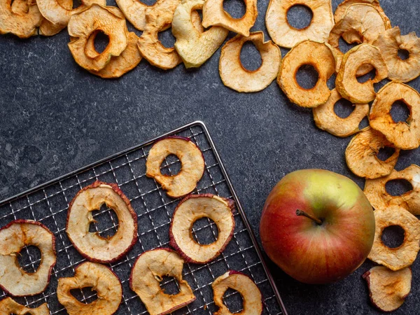 Dried slices of red and yellow apples, and fresh apple, rich in fiber and iron, healthy snack — Stock Photo, Image