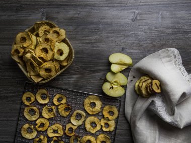 Hasır sepet ahşap masada lezzetli elma cips, mutfak çarşaf havlusu ile, kopya alanı