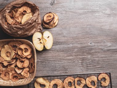 Ahşap masada lezzetli elma cipsi, sağlıklı vegan vejetaryen meyve çerez veya yemek pişirmek için madde