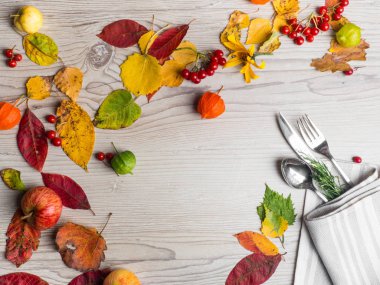 Sonbahar veya sonbahar temalı yer ayarı bir bıçak, çatal ve peçete, renkli yaprakları, berry