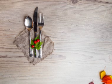 yeşil yapraklı ahşap yüzeyüzerinde tatil masa çatal