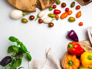 Beyaz masada eko kağıt torbalarda çiğ sebze . taze domates, fesleğen, patlıcan, biber görünümü. Sağlıklı beslenme konsepti.